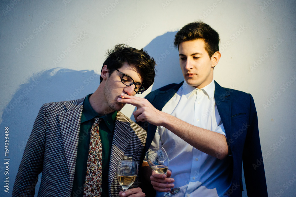sharing a cigarette with someone meaning Young friends sharing a cigarette Stock Photo