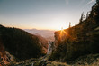 hiker standing on a cliff at sunset with beautiful panorama view to a city