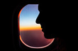 © Mosuno/Stocksy - Silhouette of a Woman Sitting in an Airplane