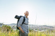 © BONNINSTUDIO/Stocksy - Portrait of a smiling senior man hiking on a mountain over the city
