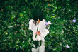 © Micky Wiswedel/Stocksy - woman hiding behind a leaf against hedge