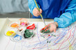 © Maa Hoo/Stocksy - Little girl painting on hand