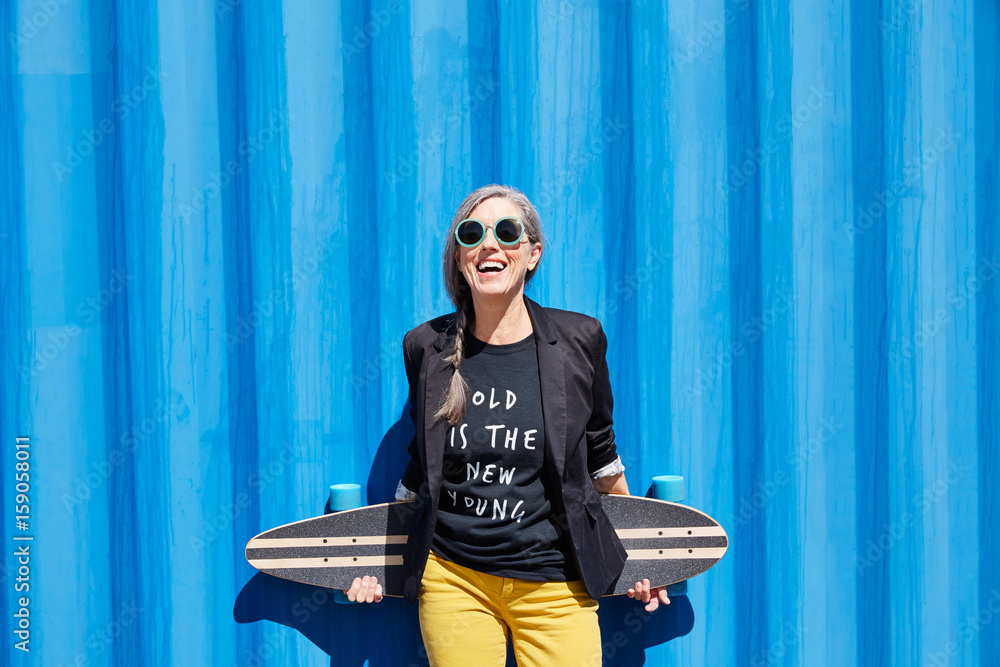 Hip and stylish senior woman with skateboard