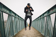 © BONNINSTUDIO/Stocksy - Cool young man jumping on a bridge