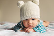 © Lauren Naefe/Stocksy - Newborn baby wearing a cute hat, laying on belly