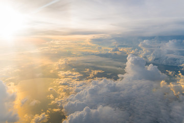 Wall Mural - white clouds and blue sky at sunrise, view from above air plane window.