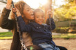 © BONNINSTUDIO/Stocksy - Black mother and her son having fun on playground swing