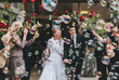 © Leander Nardin/Stocksy - friends celebrating just married couple with soap bubbles and red roses