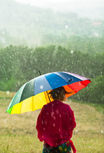 Woman With Colorful Umbrella Enjoying Rain In The Meadow