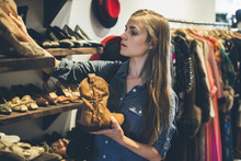Young Woman Looking For New Shoes In A Vintage Store