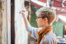 Young Woman Drawing A Colorful Mural