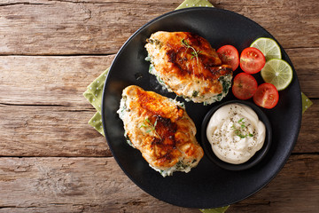 Canvas Print - Baked chicken breast stuffed with cheese and spinach, close-up. Horizontal top view