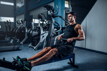 Muscular man workout on exercise machine