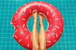 © blackday - Female legs and inflatable swim ring in shape of donut