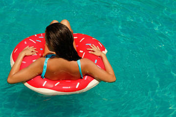 Beautiful woman and inflatable swim ring in shape of donut