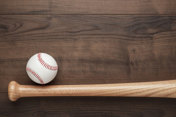 closeup of baseball bat and ball on wooden table with copy space