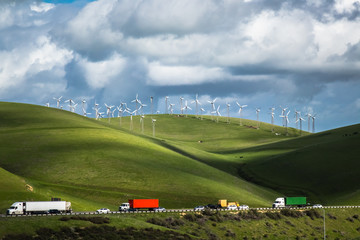 Wind turbines on a hillside, against the backdrop of cloud-filled blue sky in the Livermore, California wind farm