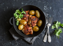 One Pot Baked Harissa Chicken And New Potatoes On A Dark Background, Top View