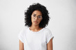 © wayhome.studio  - Serious and sad black woman with Afro haircut wearing big elegant glasses and casual clothes posing in studio over white background having thoughtful expression. People, lifestyle, emotions concept