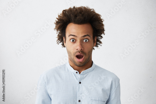 Studio Portrait Of Bug Eyed Dark Skinned Man With Bushy Dark Hair