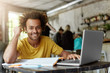 © wayhome.studio  - Happy positive African American college student with cheerful cute smile using wireless internet connection on laptop computer at coffee shop while looking for information online for research project