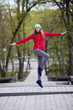 © Елена Кравчук - Young smiling woman jump training, outdoor workout in city park, forest, nature