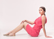 © HD92 - one young Caucasian woman 20s, 20-29 years, fashion model posing, studio, sitting white background, fashionable pink dress, looking to camera