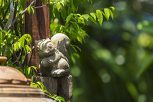 Squirrel Stucco Doll In The Garden With Green Bokeh Background.