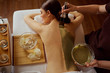 © Studio Romantic - Young woman is put on a mask on her back in  spa salon.