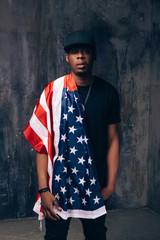 Proud afro american man with american flag on dark background. Patriot, national event celebration, independence day, pride, usa citizen concept