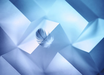 Aufkleber - Abstract geometric blue background with triangles and rectangles of paper and a Light air feather in balance on the edge of the paper edge.