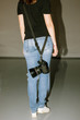 © Photodrive - Unrecognizable photographer holding photo camera on belt. Casual woman in jeans with professional equipment back view