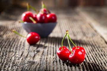 Wall Mural - Group dew-covered cherries on old wooden table