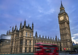 Fototapeta Big Ben - Panoramic view of Big Ben and Westminster parliament in London, United Kingdom at dusk with blurry double decker London bus on the foreground.