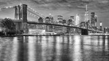 Fototapeta Nowy Jork - Black and white photo of Brooklyn Bridge and Manhattan at night, New York City, USA.