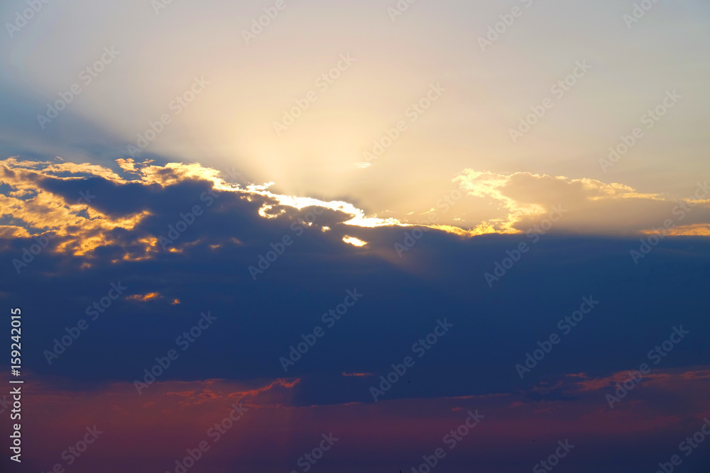 Beautiful cloudy sunset with sunbeams