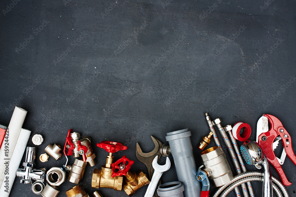 Top view of the plumbing equipment on a black background - obrazy, fototapety, plakaty 