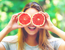 Happy Young Woman Holding Grapefruit