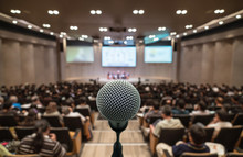 Microphone Over The Abstract Blurred Photo Of Conference Hall Or Seminar Room With Attendee Background, Business Meeting Concept