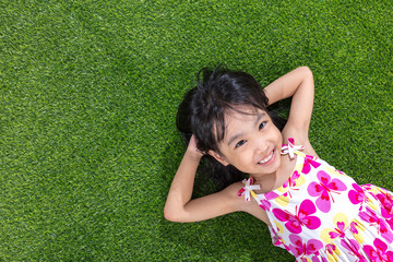 Wall Mural - Asian Chinese little girl lying on the grass