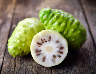 noni fruit on wooden background