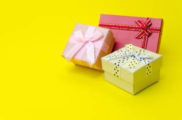 Wall Mural - mini colorful gift box on yellow background, holiday sale and online shopping concept, selective focus, copy space