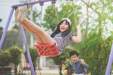 asian girl swinging on the playground