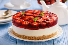 Homemade Strawberry Cheesecake On Blue Wooden Background.