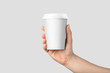 © PrimeMockup - Mockup of male hand holding a Coffee paper cup isolated on light grey background.