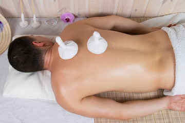 massage with herbal bags man for a healthy back