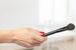 © fotofabrika - female hand holding a professional makeup brush