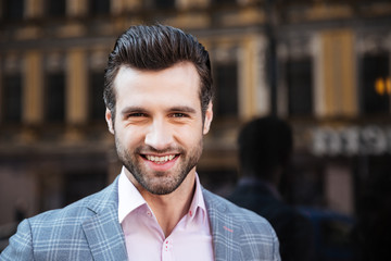 Wall Mural - Smiling handsome man in a jacket looking at camera