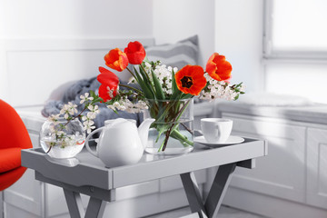 Wall Mural - Vase with beautiful flowers and tea set on table in modern veranda interior