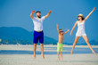 © schamin - Happy young family of three having fun on the desert sunny beach
